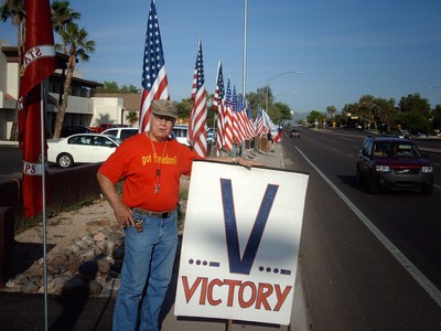 Frank with sign 'Victory' while leaning right