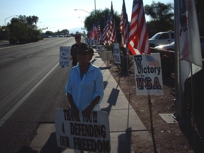 smiling lady with sign 'Thank You For Defending Our Freedom'